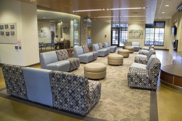 Williams Village North Hall lounge showing chairs, ottomans, carpet and tile flooring, windows