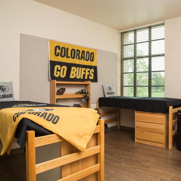 Double res hall room with two beds, desks, chairs, microfridge, window