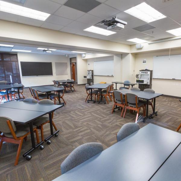 Large residence hall classroom in Will Vill North with move-able tables, windows, chalkboard
