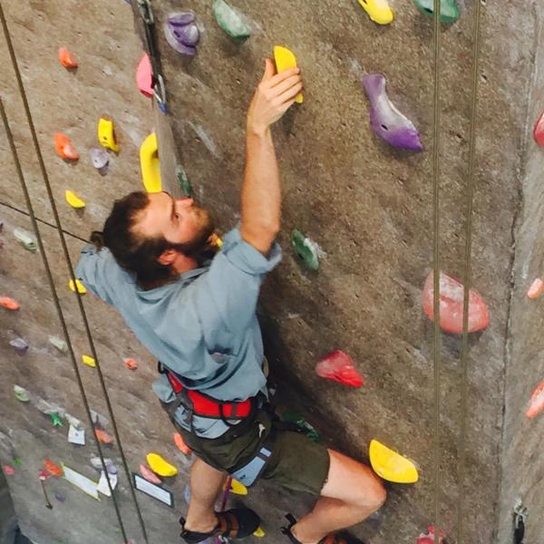 Guy climbing inside climbing wall at CU rec center