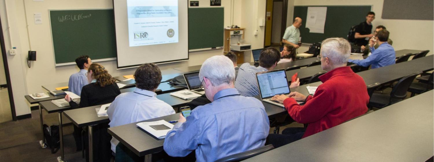 Attendees sitting in an academic classroom participating in a lecture