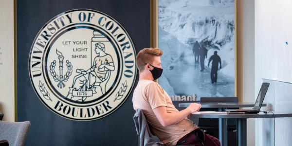 A student wears a face covering while working in the CASE building. (Photo by Glenn Asakawa/University of Colorado)