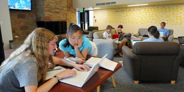 Two students work on a project in the common area of Andrews Hall
