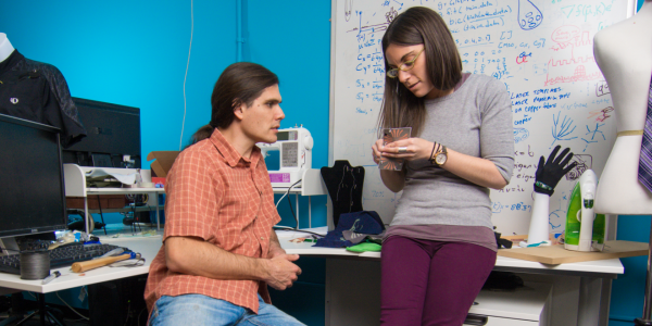 Two graduate students discuss a project in their wearable technology lab
