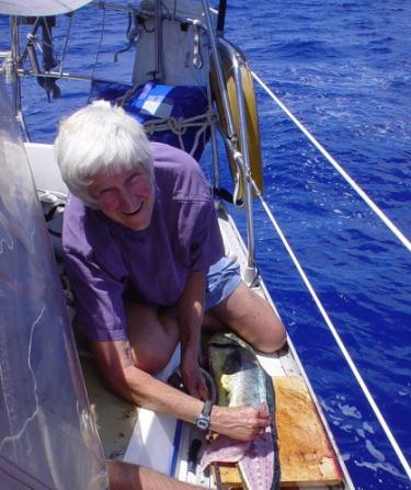 Evi Nemeth cleans a fish on the deck of a sailboat
