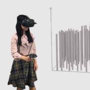 A person wearing a VR headset stands next to computer generated graph 