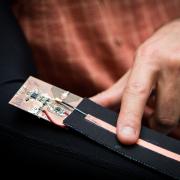 A close-up view of the wearable device being controlled with a finger swipe.