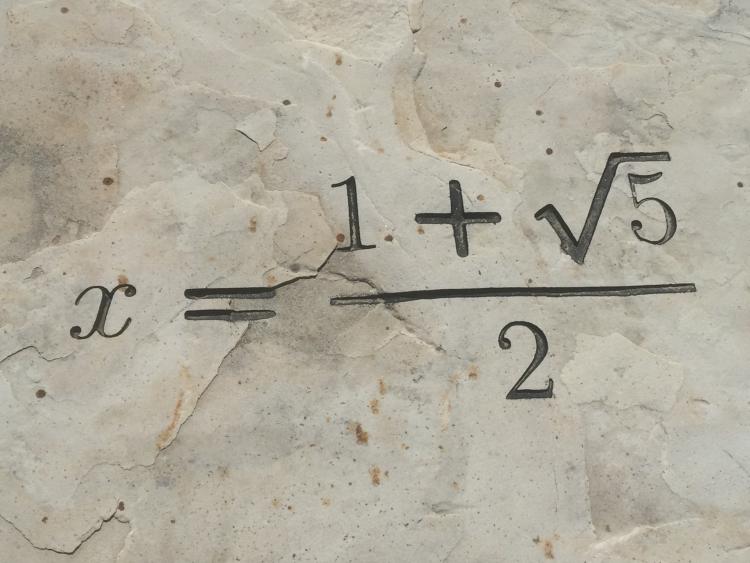 The equation x = (1+ squarer of 5) / 2 etched in stone