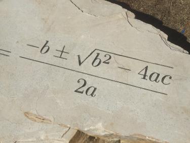 The quadratic equation etched on a rock
