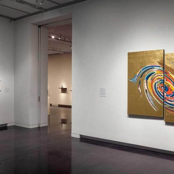 Installation view of diptych painting, gold with multi-color swirls