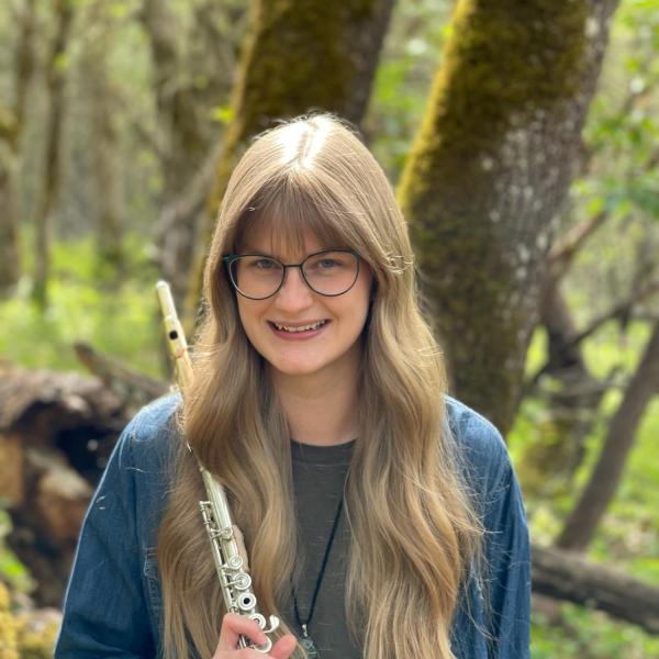 Photo of a woman with glasses, long blonde hair, and a flute.