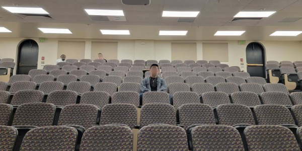 Student in auditorium with face blurred out