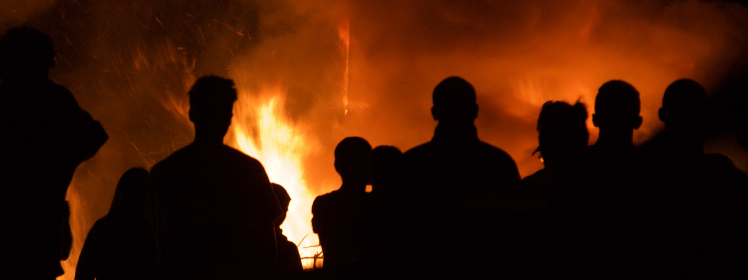 Silhouette of firefighters in front of a blaze