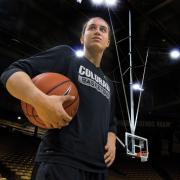 Haley Smith on the basketball court holding a basketball looking into the distance