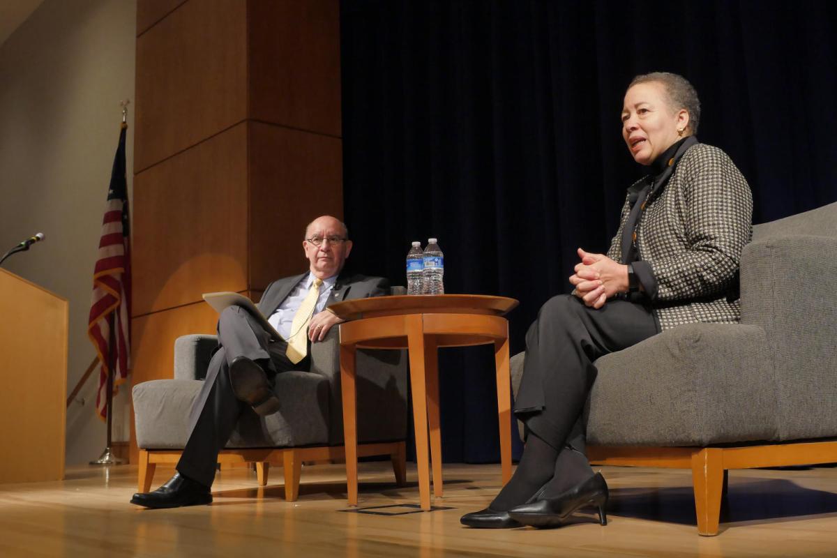 professors sitting on a stage for a discussion
