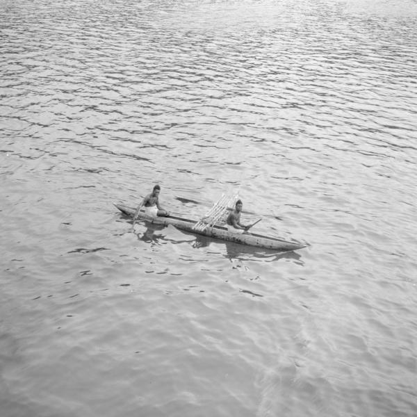 Two children in canoe in the middle of the sea