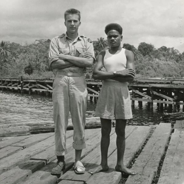 Bud standing with young man on dock.