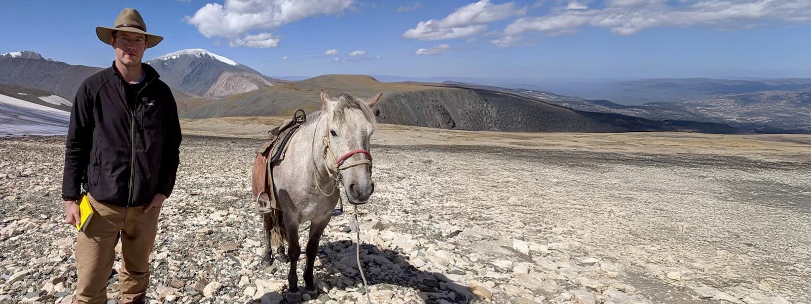 Will Taylor standing by horse in Mongolian plains