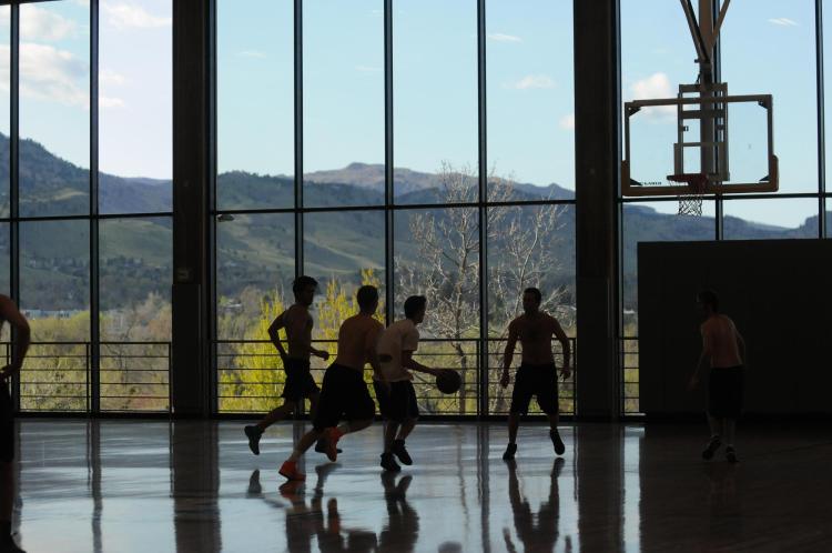 A group of students play basketball at The Rec.