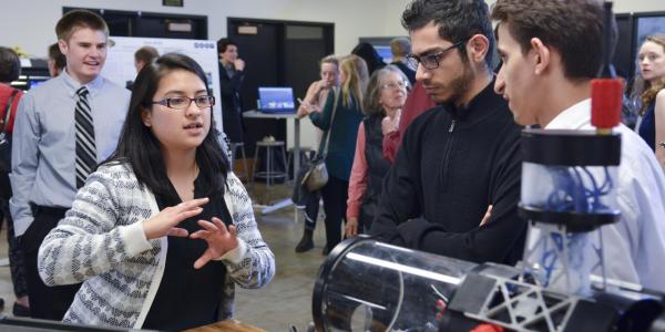A student explains her project to visitors at the 2017 ECEE senior design expo. 