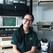 Giselle Koo sits in a lab filled with RF equipment