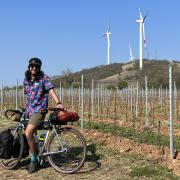 Nikhar Abbas cycling by wind turbines.