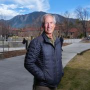 Scott King on campus near the Rustandy Building, with the Flatirons in the background