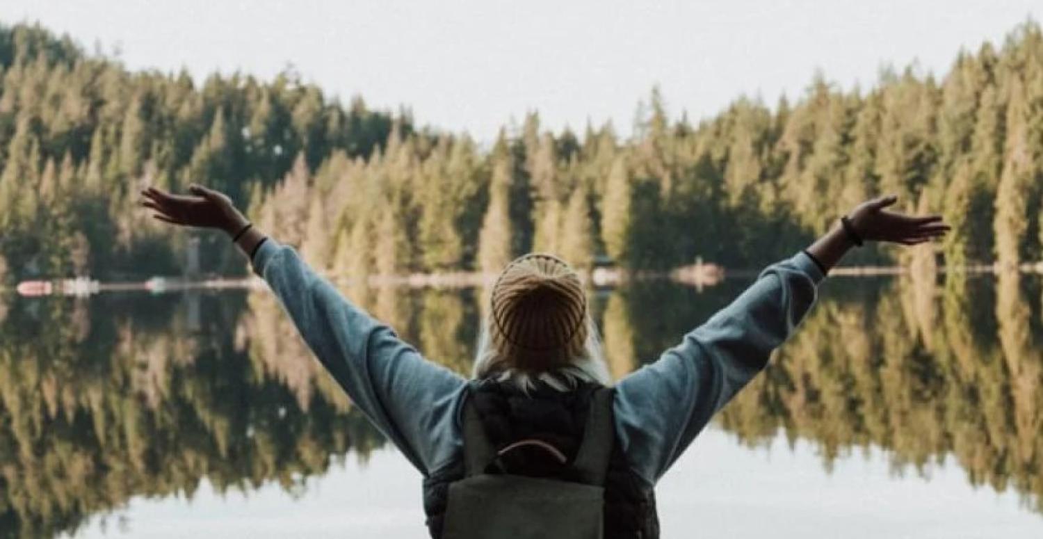 hiker in front of lake