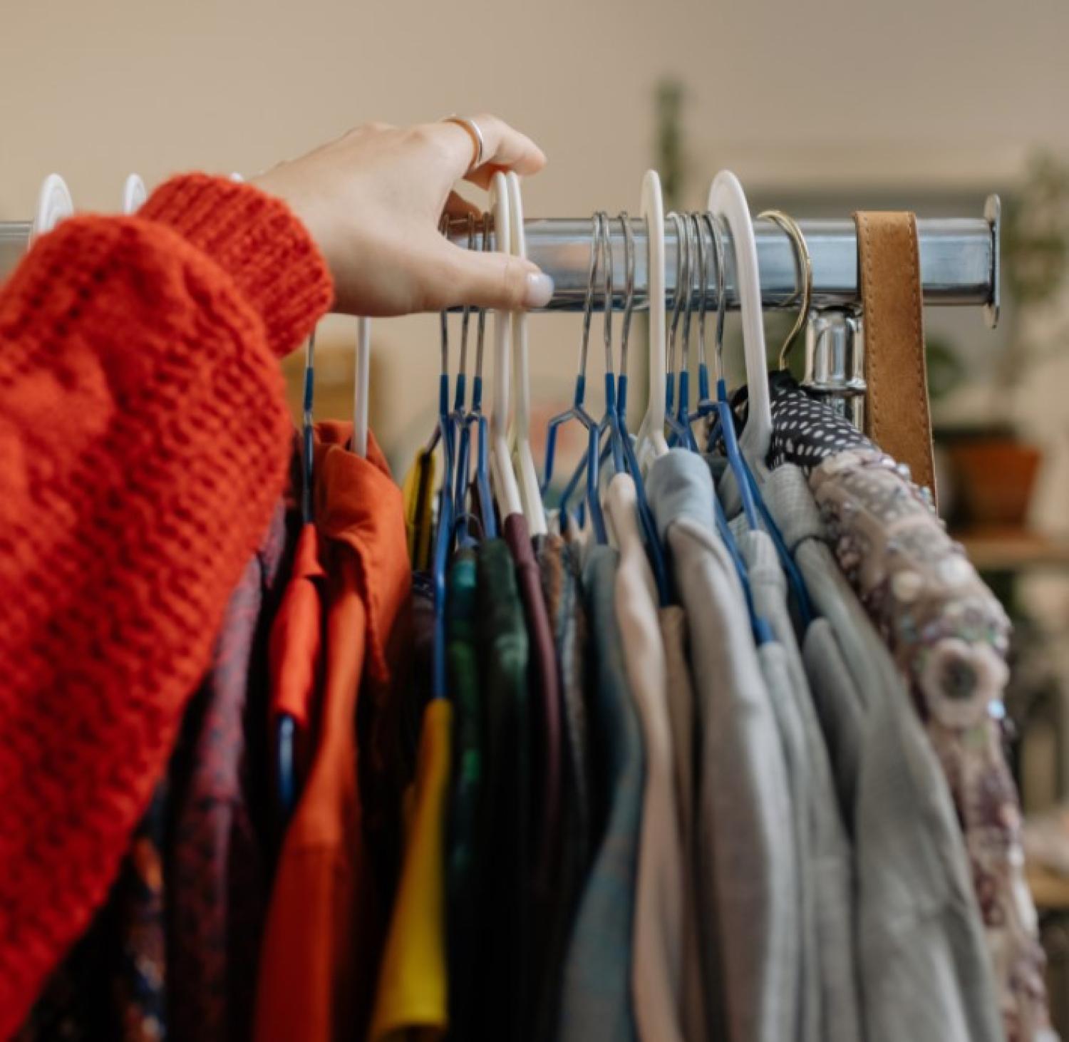 hand reaching for clothing rack