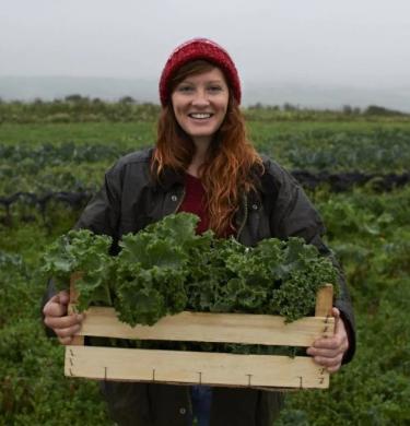 woman on a farm holding lettuce