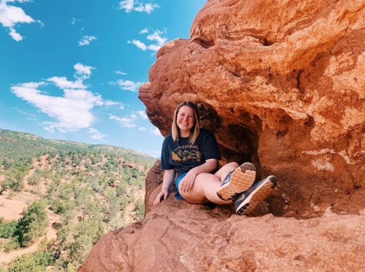 Brooke relaxes on a rock outcropping during a hike