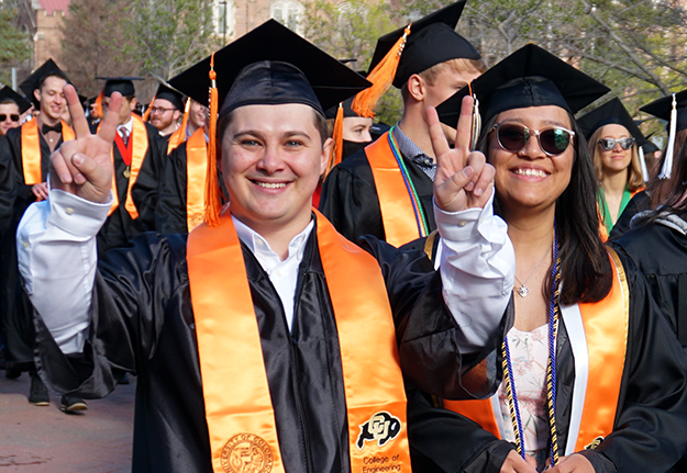 2022 graduating engineering students walk across campus wearing their regalia