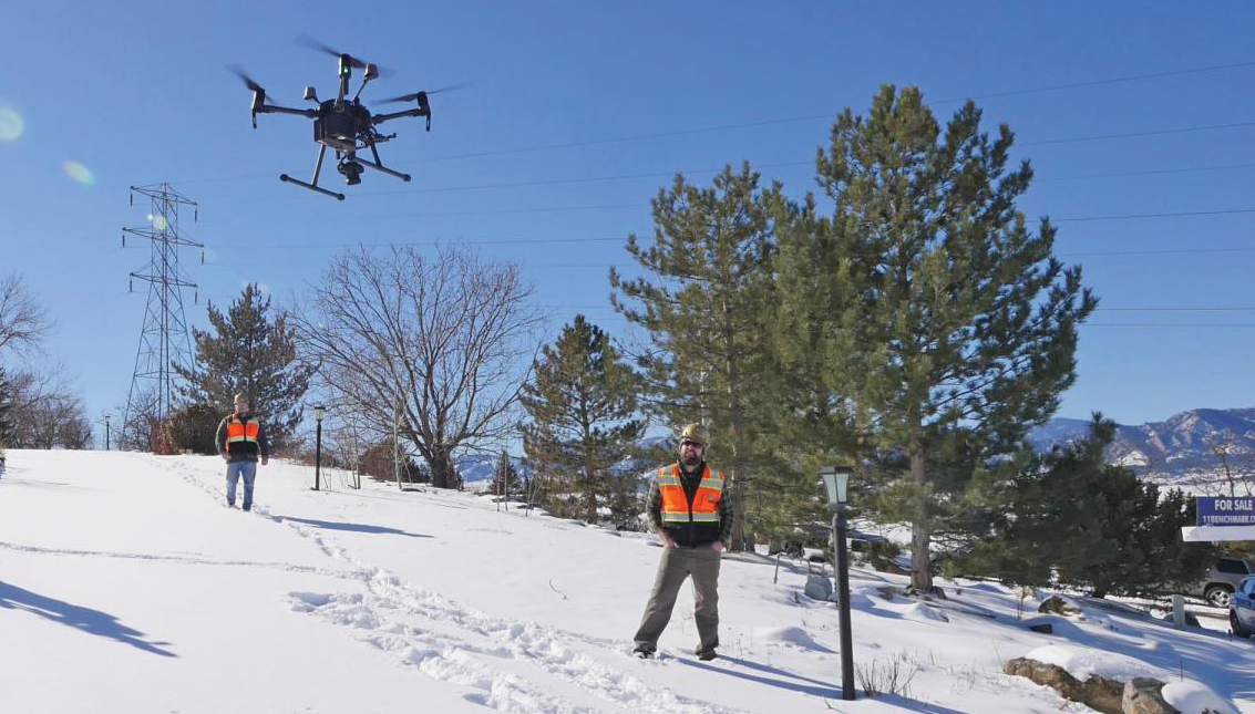 Researchers watch a drone take off from the Spanish Hills neighborhood.