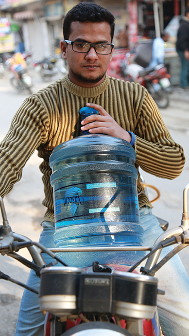 Guy with large container of water on a motorcycle