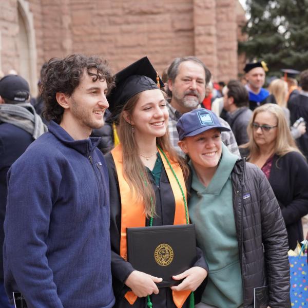 Grad posing for photo with friends