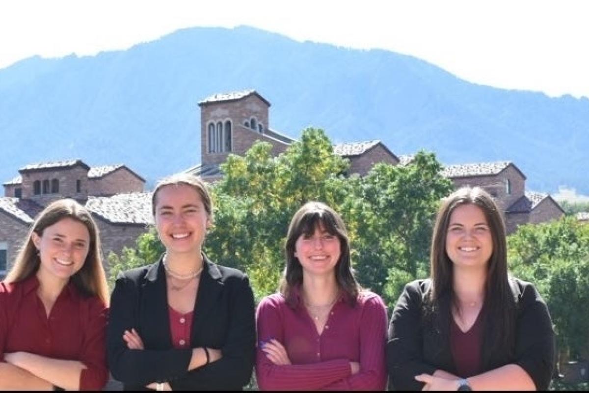 A photo of four women superimposed over a photo of campus with the flatirons in the distance
