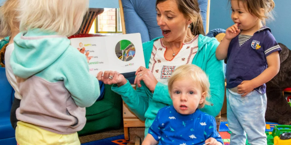 A staff member reads to children at the CU Children's Center
