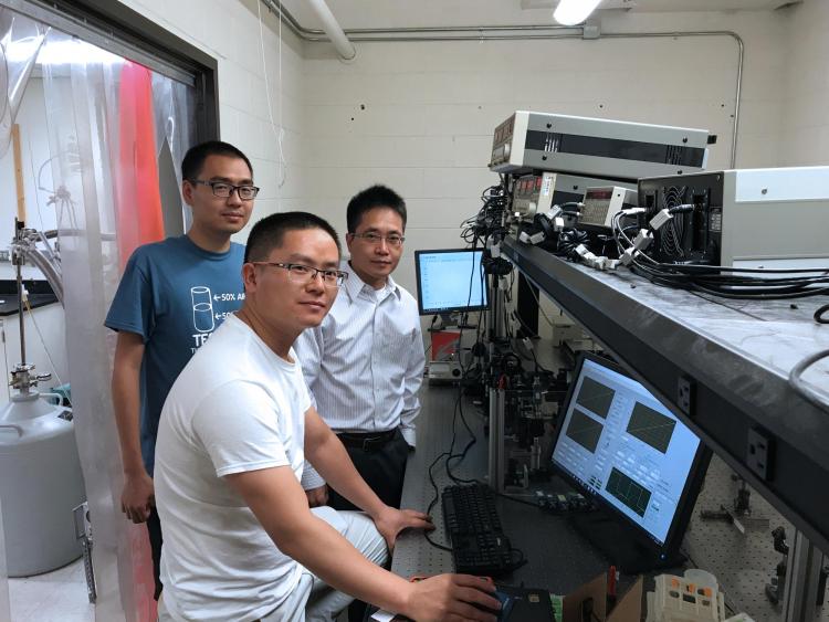 Ronggui Yang in a lab with two students.