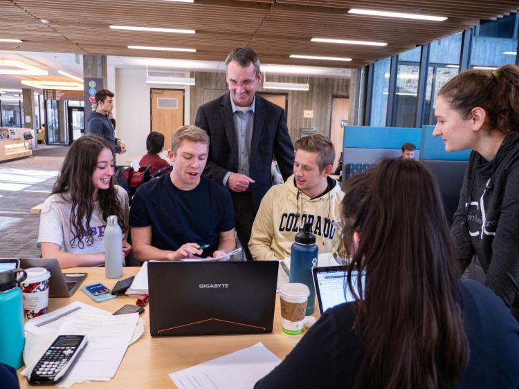 Keith Molenaar working with students in the lobby of the engineering center.