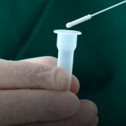 Person holding a COVID test swab and test tube