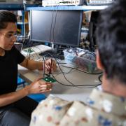 A student works with electronics in a lab