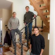 Morris, Kurtz and Donado Quintero stand on a staircase inside the home