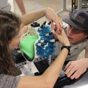 Two team members working on the helmet.