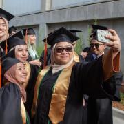 Female engineering students pose for a selfie at graduation