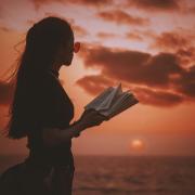 WOMAN READING AT SUNSET