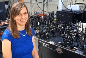 Juliet Gopinath next to an optical table in her lab