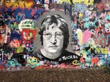 Wall of graffiti with illustration of John Lennon