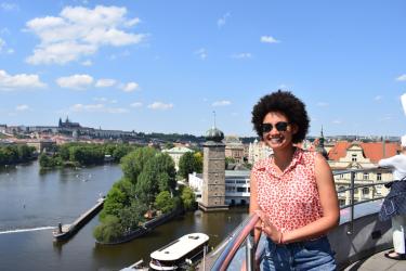 Student posing overlooking landscape of river and the city of Prague