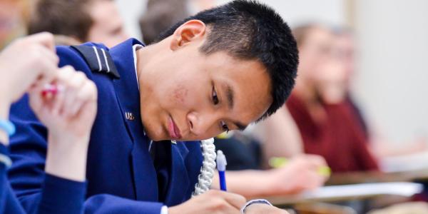 ROTC student taking notes in class.