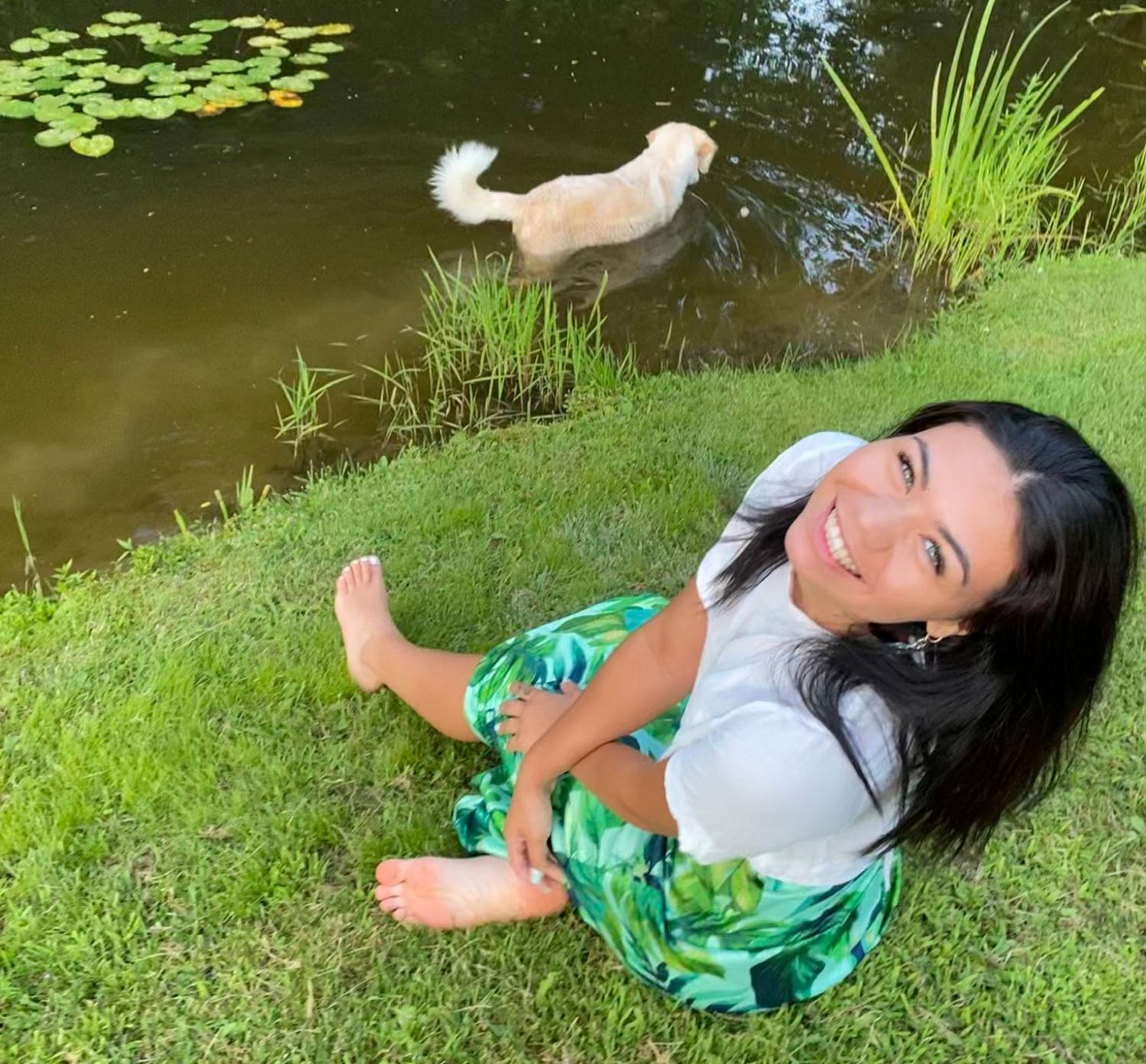 Tia Kennedy with her dog wading in pond